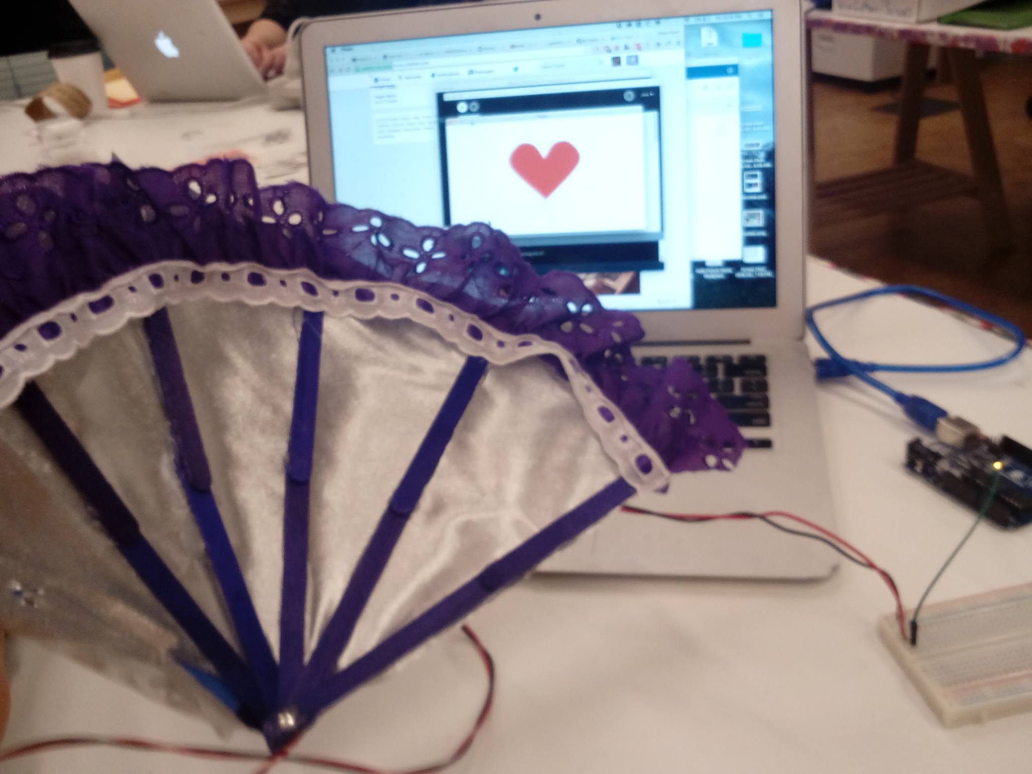 The fan sitting next to a laptop computer.