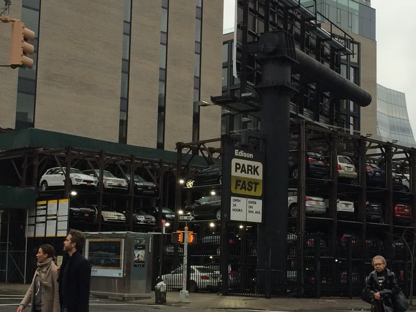 A parking lot where cars are put up on some kind of metallic vertical scaffolding.