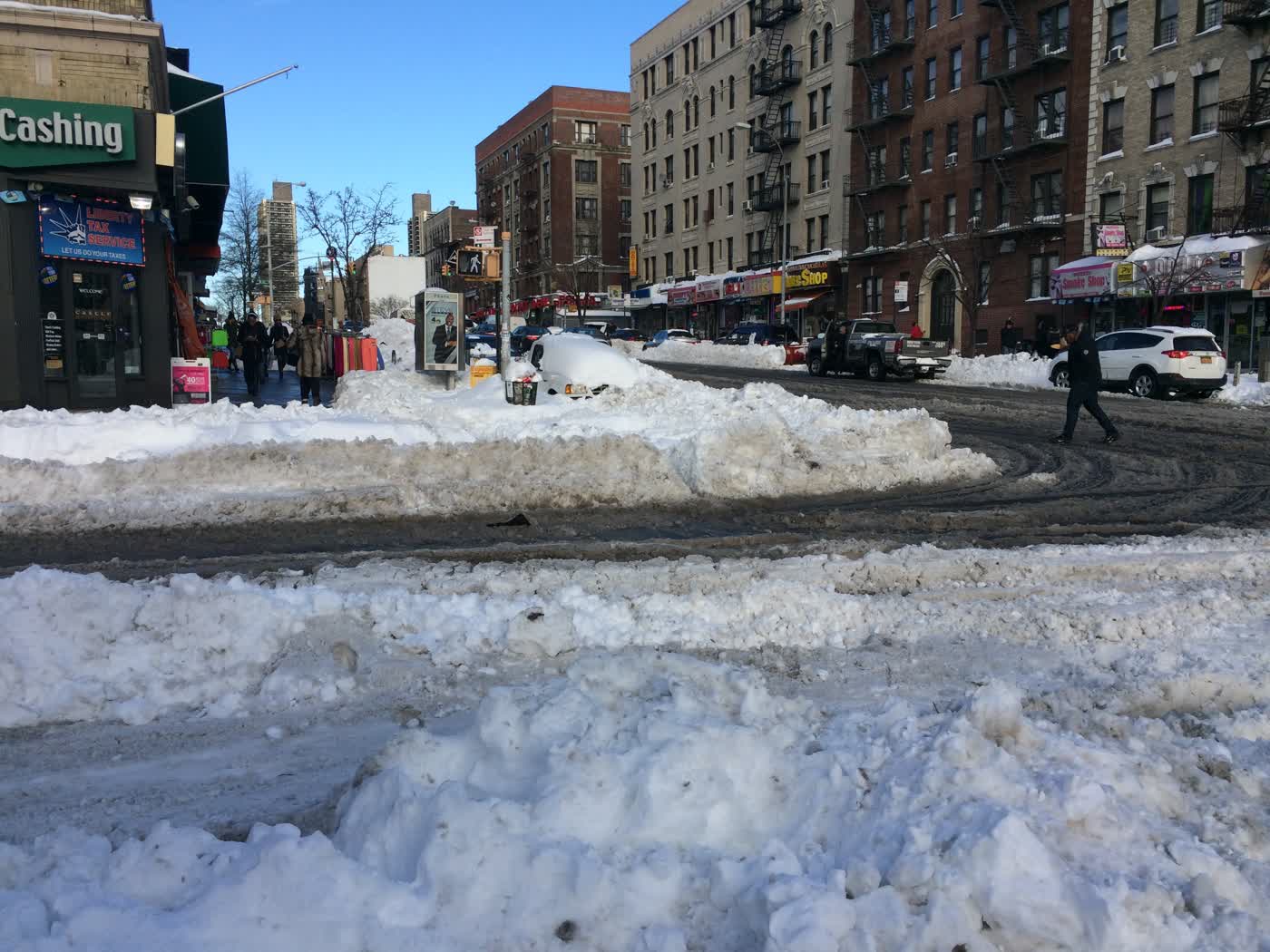 A snowy street with huge snowbanks.