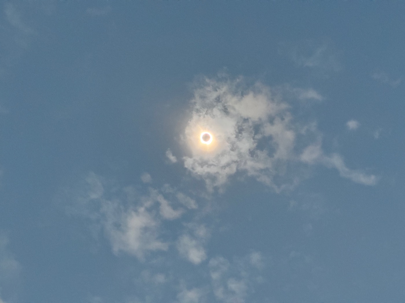 A picture of the total eclipse, behind a wisp of cloud.
